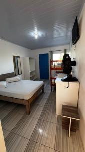 ein Schlafzimmer mit zwei Betten und einem Fernseher an der Wand in der Unterkunft Beira Mar Residencial in Capão da Canoa