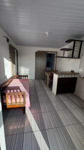 ein Zimmer mit einem Bett und einem Holzboden in der Unterkunft Beira Mar Residencial in Capão da Canoa