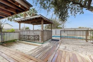 a wooden deck with a gazebo next to a pool at The Saltbox in Padre Island