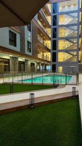 a large building with a swimming pool in front of a building at Mfj Marbella Stay دخول ذاتي بموقف خاص وإطلالة مسبح in Al Khobar
