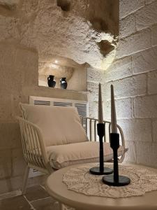 een woonkamer met een bank en een tafel met kaarsen bij L'Incanto Caves in Matera