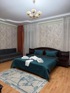 een slaapkamer met een groen bed en handdoeken bij Сункар in Uchitelʼ