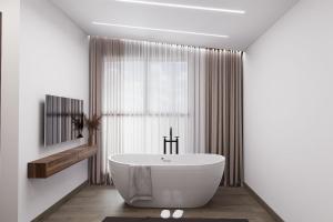 een badkamer met een wit bad voor een raam bij Montéa Villa in Brezovicë