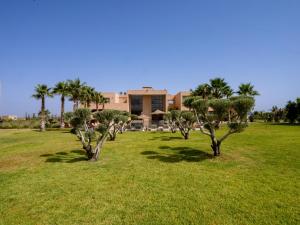 SUMAHAN SUITES & SPA في مراكش: مجموعة اشجار في حقل امام مبنى