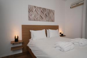 特拉维夫One Apartments TLV的卧室里有一张白色的床，床上放着毛巾