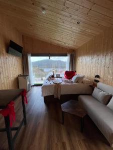 Cabañas O Recuncho do Sor في أو باركييرو: غرفة نوم كبيرة مع سرير كبير وأريكة