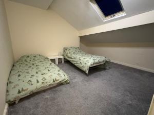 een slaapkamer met twee bedden en een raam bij Sowerby Homes in Sowerby Bridge +18 foto's
