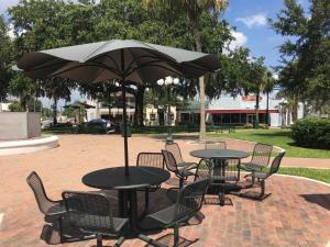 ein Tisch und Stühle mit einem Sonnenschirm auf einer Terrasse in der Unterkunft Historic Sebring Downtown Home in Sebring