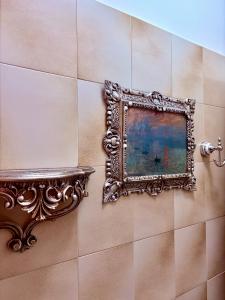 een spiegel aan een muur met een schilderij erop bij Hotel Continental Cassino in Cassino