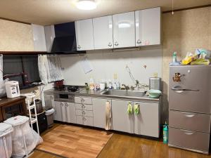 een keuken met een spoelbak en een roestvrijstalen koelkast bij 桜の家 in Saitama +16 foto's
