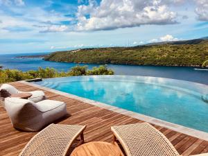 een zwembad op een terras met uitzicht op het water bij Les Terrasses Ceningan in Nusa Lembongan