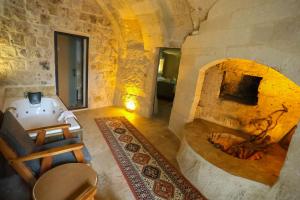 a large stone room with a fireplace in a house at Kayaharman cave otel in Nar