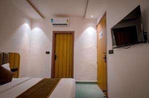 een slaapkamer met een bed en een deur met een televisie bij Troy Resorts and wellness in Zirakpur