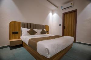een slaapkamer met een groot bed met een houten hoofdeinde bij Troy Resorts and wellness in Zirakpur +18 foto's
