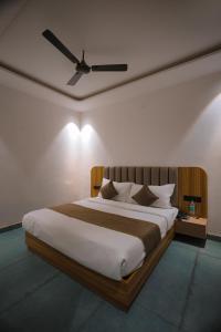 een slaapkamer met een groot bed met een plafondventilator bij Troy Resorts and wellness in Zirakpur