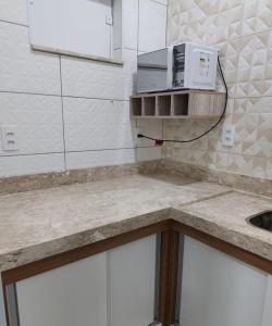 un comptoir de cuisine avec un micro-ondes et un évier dans l'établissement Aconchego Perfeito em São Pedro SP, à São Pedro