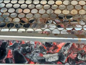 a metal bench sitting over a fire at Suite 05 em casa Beira mar, com ar condicionado , cozinha completa com Micro ondas air fryer forno elétrico fogão Geladeira freezer gelagua e cafeteira elétrica Tudo para vc se sentir em casa além de um Deck com churrasqueira vista mar in Icapuí