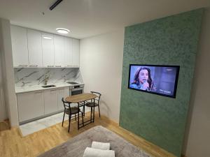 a living room with a television hanging on a wall at Apartman "Paolo" Istočno Sarajevo in Vranješ
