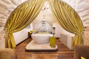 un bagno con una grande vasca in una stanza di Zerzembe Boutique Hotel a Şanlıurfa