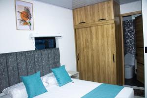 a bedroom with a bed and a wooden cabinet at Pura Vida in Quibdó