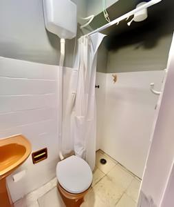 a bathroom with a toilet and a sink at Sol Calor e Mar, achei minha pousada in Matinhos