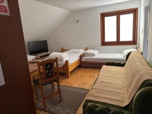 a living room with two beds and a television at Apartments and Rooms Vicko in Brzeće