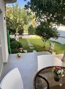 een patio met een tafel en stoelen en een tuin bij Arsuz Suit 1 in Hatay