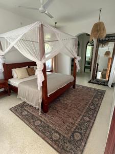 een slaapkamer met een hemelbed bij Natural living eco resort in Malindi