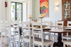 una sala da pranzo con un tavolo e sedie bianche di Quinta da Paciencia a Sintra