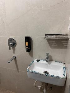 a bathroom sink with a soap dispenser on a wall at Maheshwari Homes in Ujjain