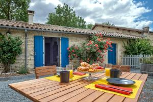 a wooden table with a plate of food on it at Gîtes de la Bernière in Brûlain +5 photos