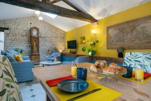 ein Esszimmer mit einem Tisch und einem Teller Brot in der Unterkunft Gîtes de la Bernière in Brûlain