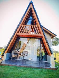 een huis met een driehoekig dak met twee stoelen bij Chalé Venanzi in São Francisco do Sul