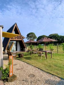een groep tafels en paraplu's in een veld bij Chalé Venanzi in São Francisco do Sul