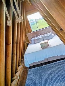 een bed in een kamer met een raam bij Chalé Venanzi in São Francisco do Sul