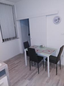 una sala da pranzo con tavolo e sedie bianchi di apartmani mikek a Domaslovec