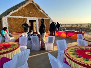 een groep mensen die voor een hut staan bij Taj heritage camp& resort in Jaisalmer