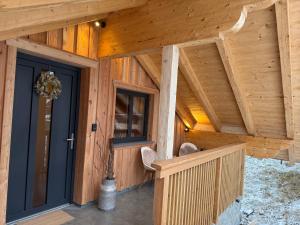 Elle offre une vue sur une maison en bois dotée d'une terrasse couverte. dans l'établissement amKampl-Ferienwohnung, à Radling