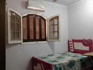 a room with a bed and two windows at شعبان in Beni Suef