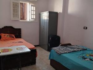 a bedroom with two beds and a dresser at شعبان in Beni Suef