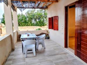 un patio con tavolo e sedie su un portico di Tebtunis Hotel a Qaryat at Ta‘mīr as Siyāḩīyah