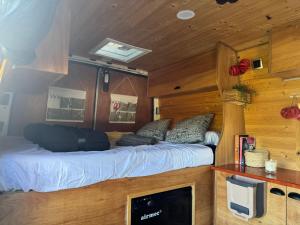 TrapicheFurgoneta camper solo hospedaje sin conducción的房间里有一张床和一台电视的卧室