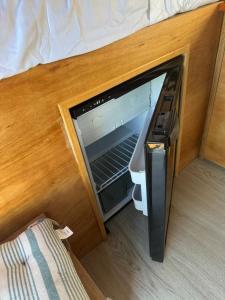 TrapicheFurgoneta camper solo hospedaje sin conducción的橱柜中冰箱的门打开了