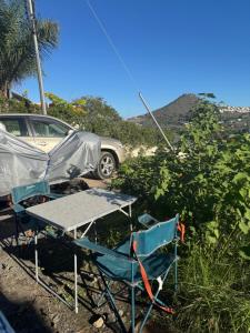 TrapicheFurgoneta camper solo hospedaje sin conducción的一张桌子、几把椅子、一个帐篷和一辆车 更多14张照片