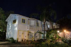 a white house at night with a palm tree at Pousada Quinta da Margem in Florianópolis