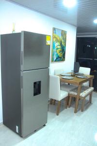 基布多Pura Vida的厨房配有桌子和不锈钢冰箱。