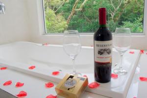 a bottle of wine and two glasses on a table at Pousada Quinta da Margem in Florianópolis