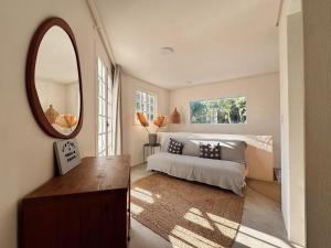 a living room with a bed and a mirror at Pousada Quinta da Margem in Florianópolis