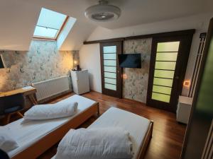 a room with two beds and a tv and windows at Sleep&Go Airport Transit Rooms Cluj-Napoca in Cluj-Napoca
