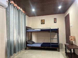 een kamer met twee stapelbedden en een bureau bij Sabari Stay in Mundakāyam +12 foto's